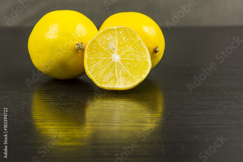 Lemons on a wooden dark background.
