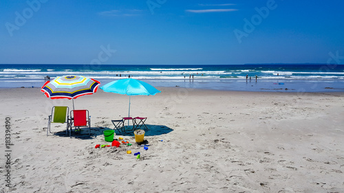 Sun umbrellas at the beach with children's toys on a sunny day