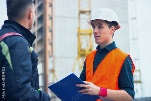 engineer talking discussing with Architect working with blueprints for architectural plan, sketching a project.