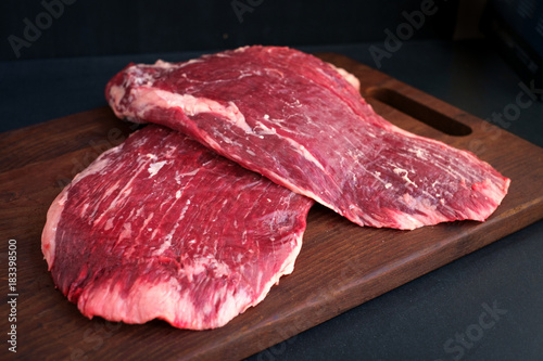 raw flank beef on a wooden Board photo