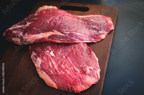 Canvastavla raw flank beef on a wooden Board