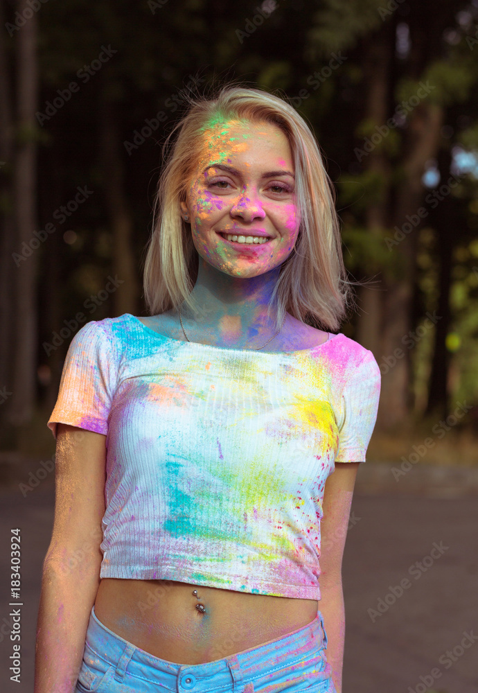 Cool young woman in white t shirt and jeans shorts covered with colorful  Holi powder Stock Photo | Adobe Stock