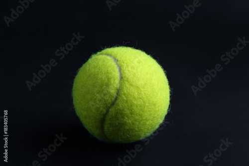 Tennis ball on black background © Africa Studio