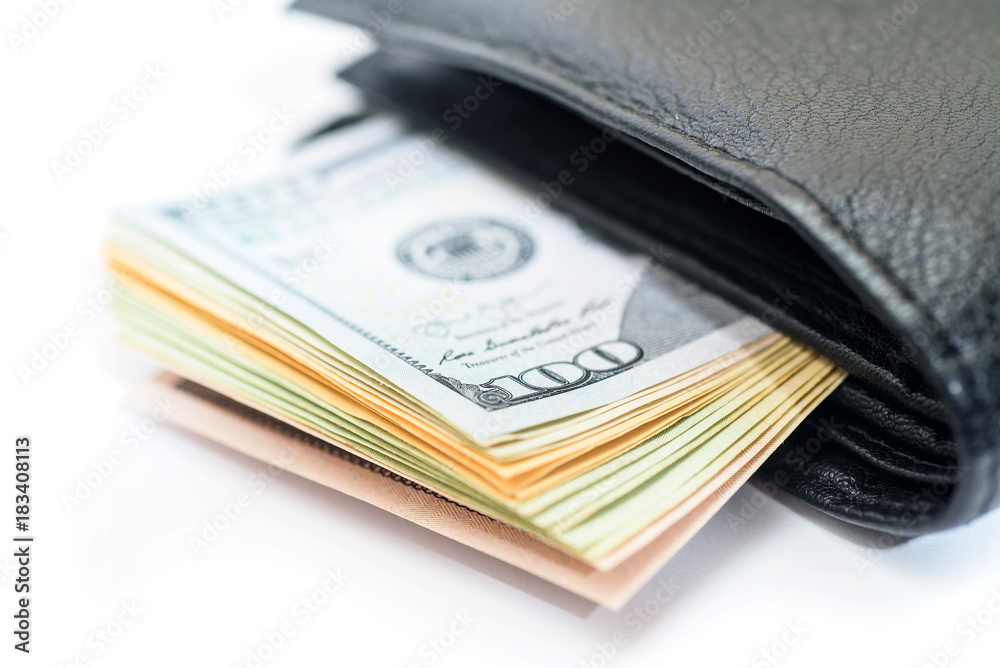 Stack of dollar bills sticking out of black wallet Stack of dollar bills sticking out of black wallet