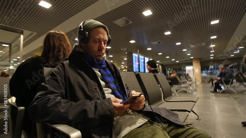 Man with the phone in the departure lounge waiting for the flight photo