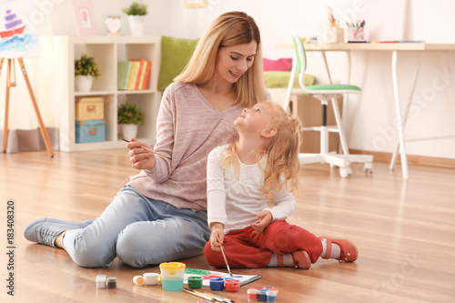 Mother with cute girl paint...