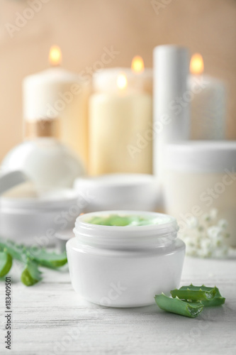 Jar with body cream on wooden table