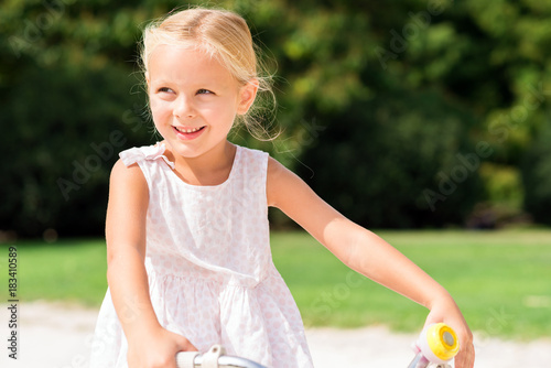 Happy child riding on her bike