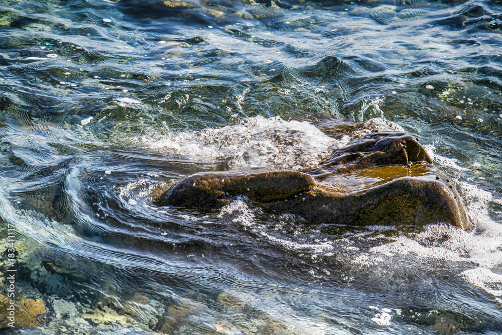 Naklejka premium Scenic water splash and a rock in ocean
