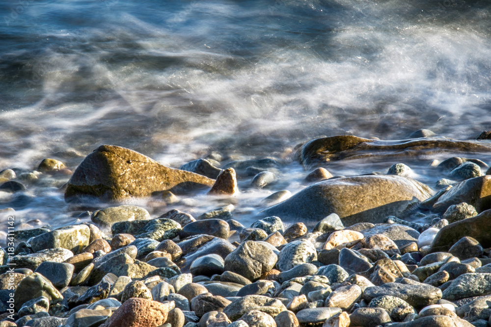 Naklejka premium Scenic water splash and a rock in ocean
