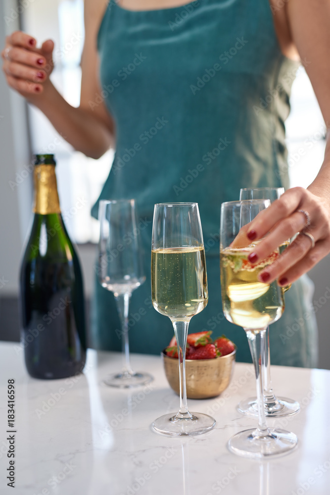 Woman serving glasses of champagne at party