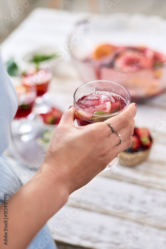 Close up on woman's hand holding cocktail sangria