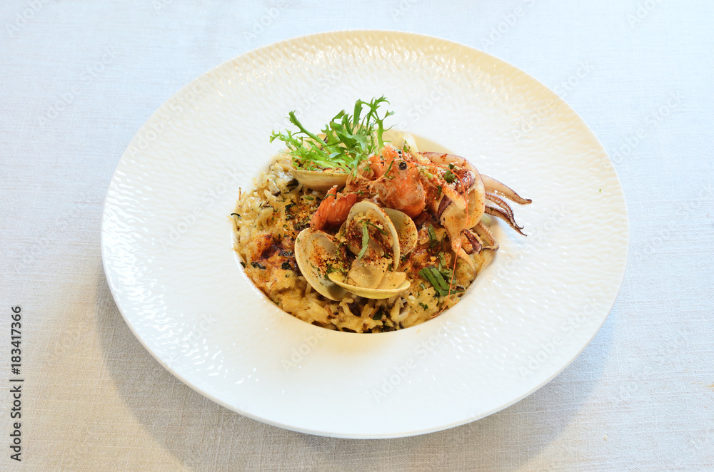 Italian seafood rice on white plate