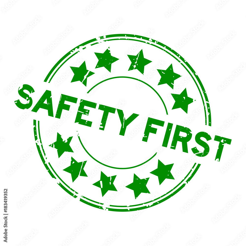 Grunge green safety first wording with star icon round rubber seal stamp on white background
