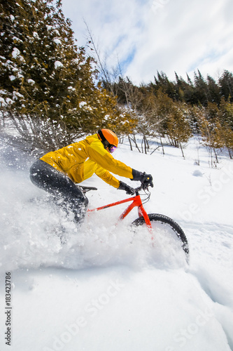 Man riding a fat bike in powder snow in the winter