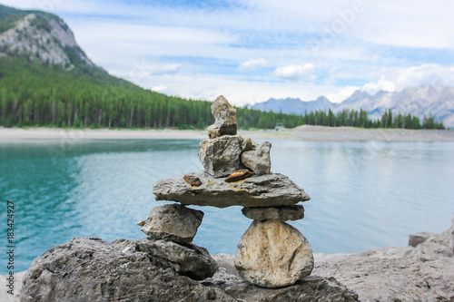 Inukshuk near the amazing green lake surrounded by mountains Canada