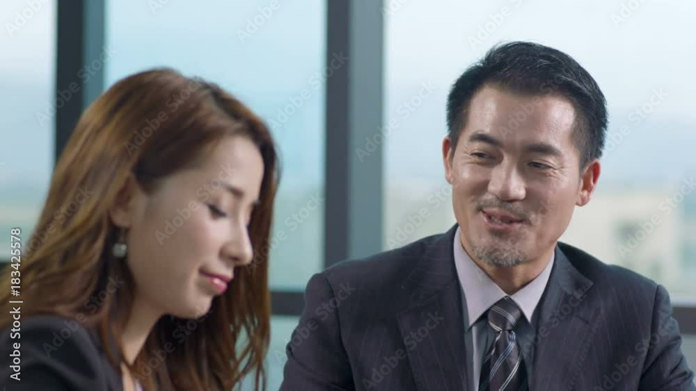 asian corporate executives discussing business in office asian corporate executives discussing business in office