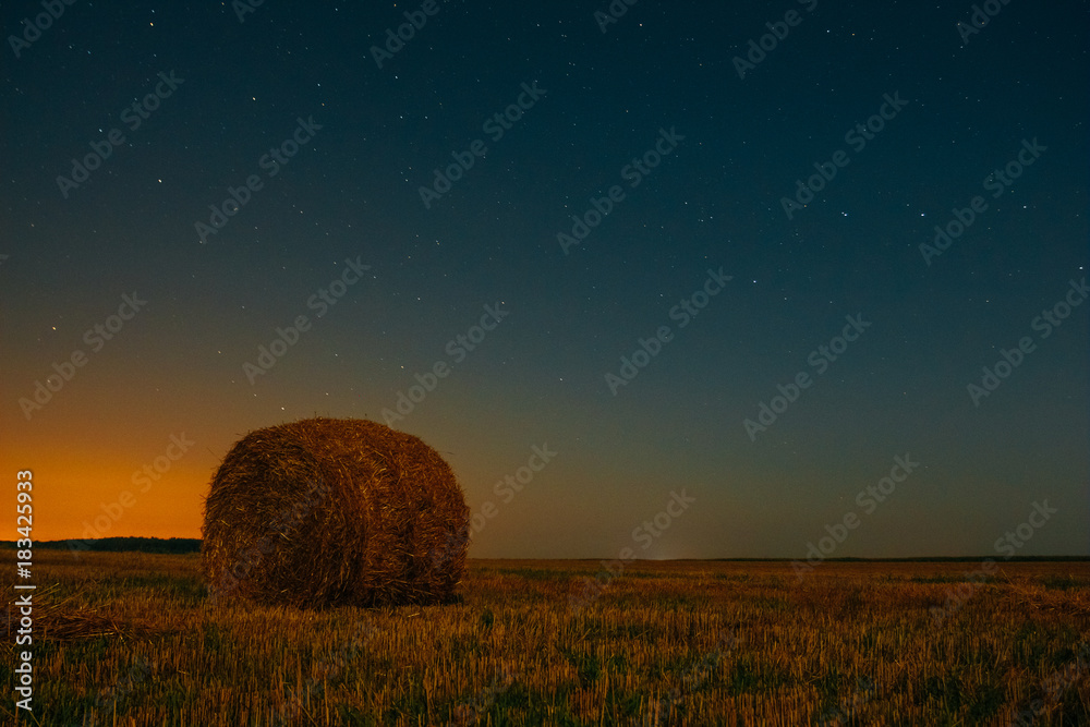 Night dark sky with a haystack in the field