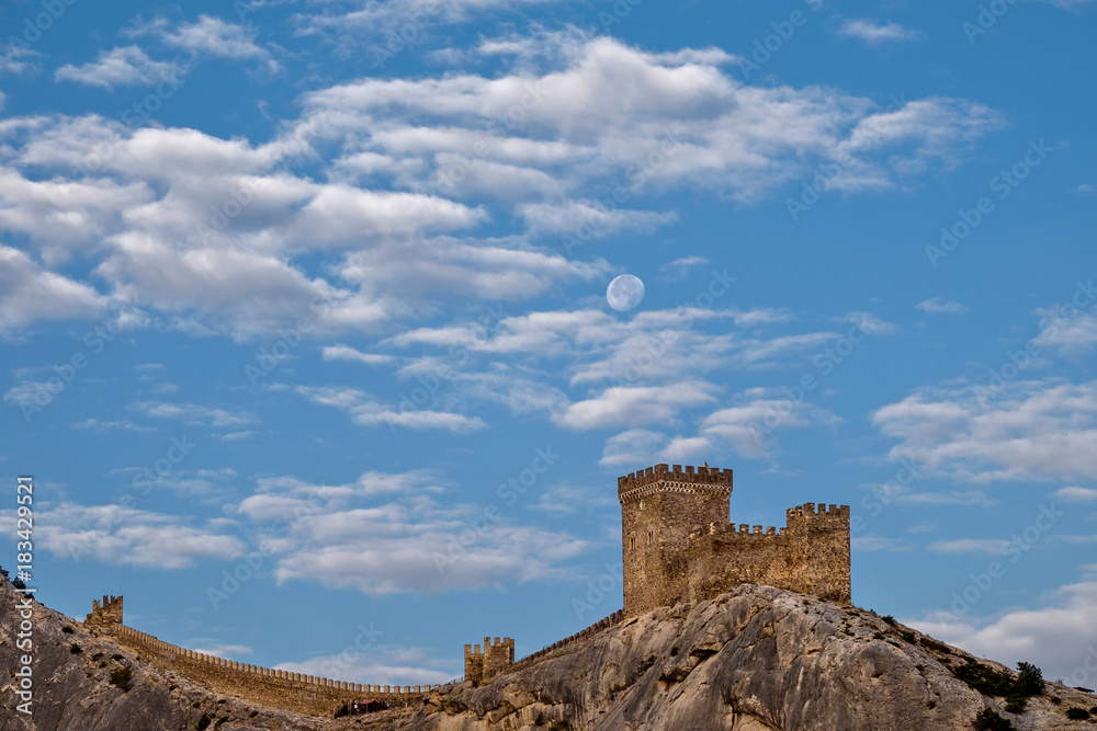 Sudak fortress and moon among clouds