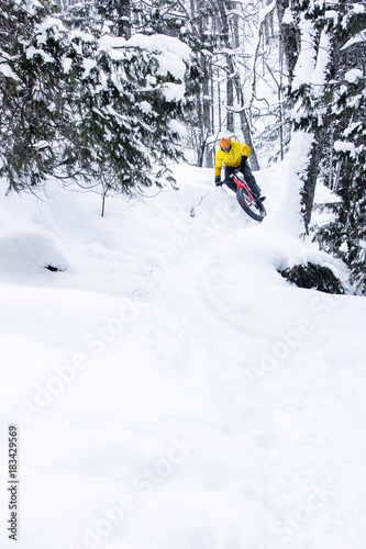 Obraz na płótnie Man riding a fat bike in the snow during winter w salonie