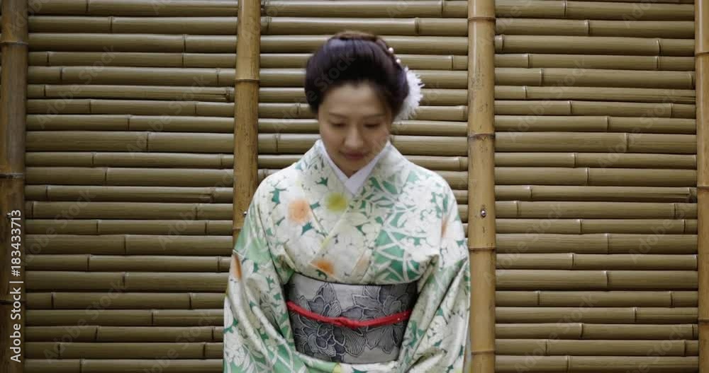 Pretty Japanese woman in kimono bows.