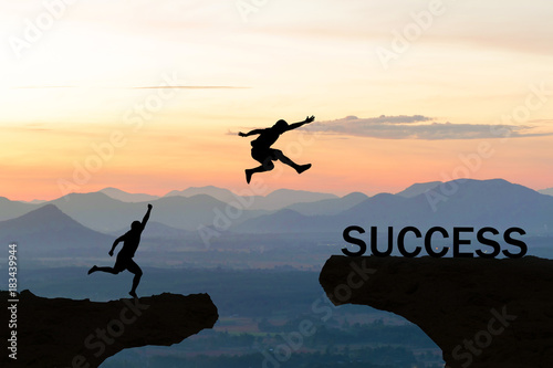 Men jump over silhouette failure commitment to success