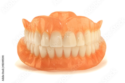 plastic full removable denture of human teeth closeup isolate on white background