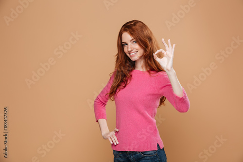 Portrait of a lovely smiling redhead girl looking at camera