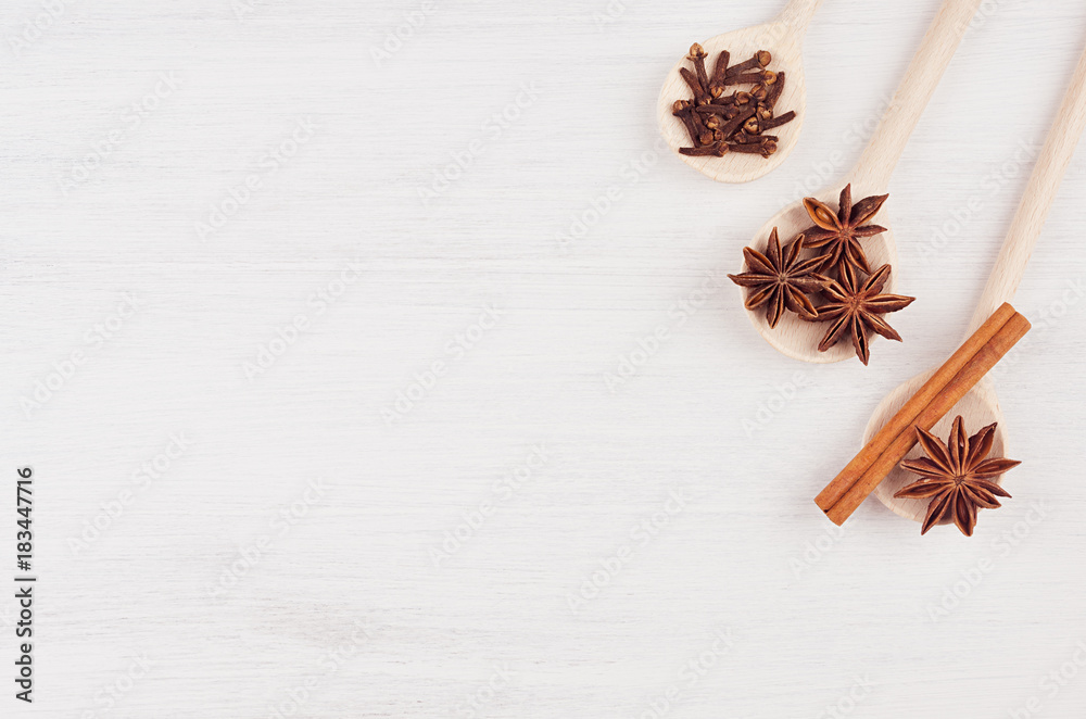 Christmas food - mulled wine background. Wood spoons with anise stars, cinnamon, clove on wood white board. Top view. Christmas food - mulled wine background. Wood spoons with anise stars, cinnamon, clove on wood white board. Top view.