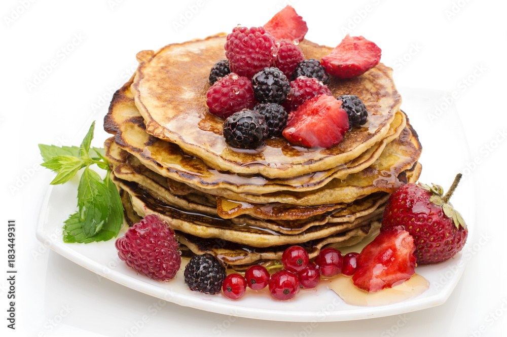 Delicious pancakes with berries and maple syrup on a white background Delicious pancakes with berries and maple syrup on a white background
