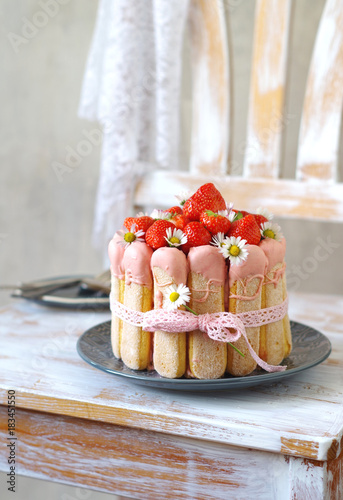 Erdbeer-Charlotte mit Gänseblümchen und rosa Schleifenband