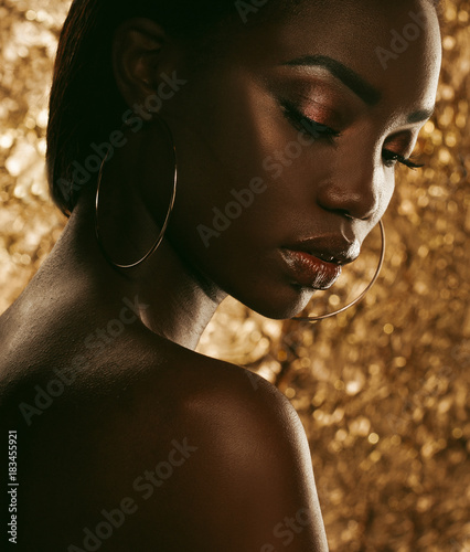 portrait of sensual young african woman against golden background