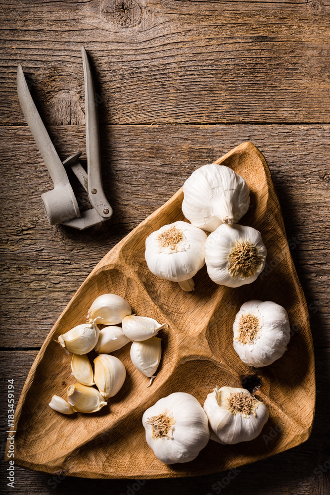 Garlic, Garlic cloves and Garlic bulb in vintage handmade wooden bowl. Top view.