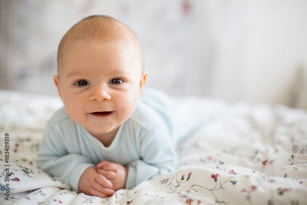 Adorable baby boy in white sunny bedroom in winter morning Adorable baby boy in white sunny bedroom in winter morning