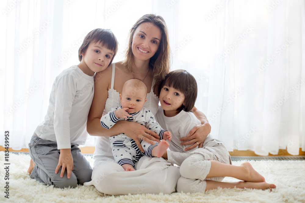Family portrait of mother and her three boys, isolated on white