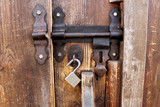 Locked padlock with chain at wooden door background, vintage, Closeup