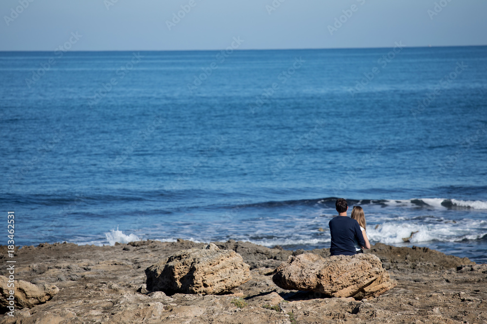 couple sitting on beach rear view
