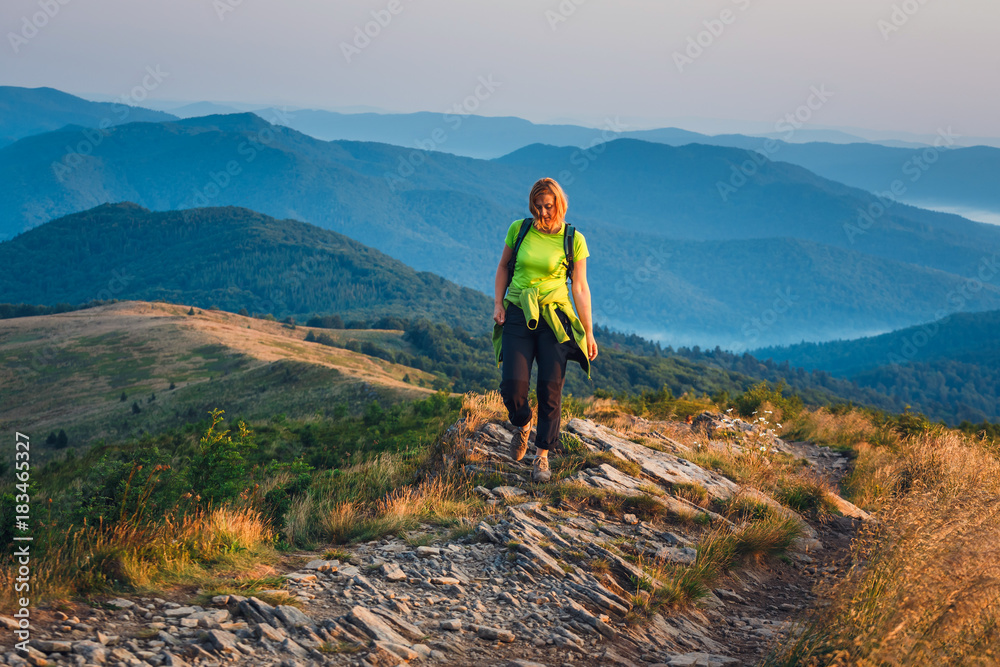 woman stands on the top and admires the beautiful sunrise