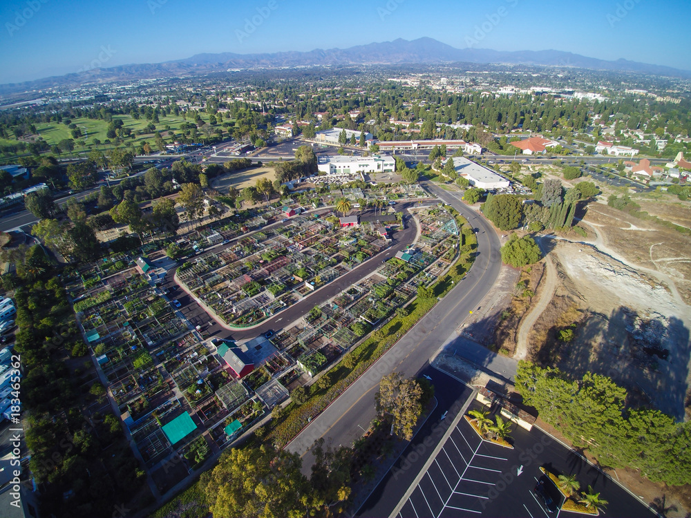 Aerial city view with roads, buildings, parks and parking lots.