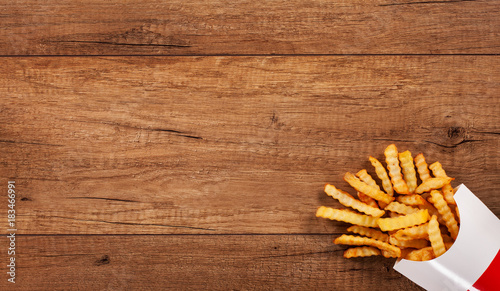 French fries on wooden table - large copy space