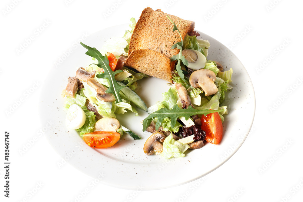 Close-up homemade fresh vegan vegetable salad with mushroom, quail egg, arugula, tomato, cucumber and bread toast. Round plate. Isolated on white