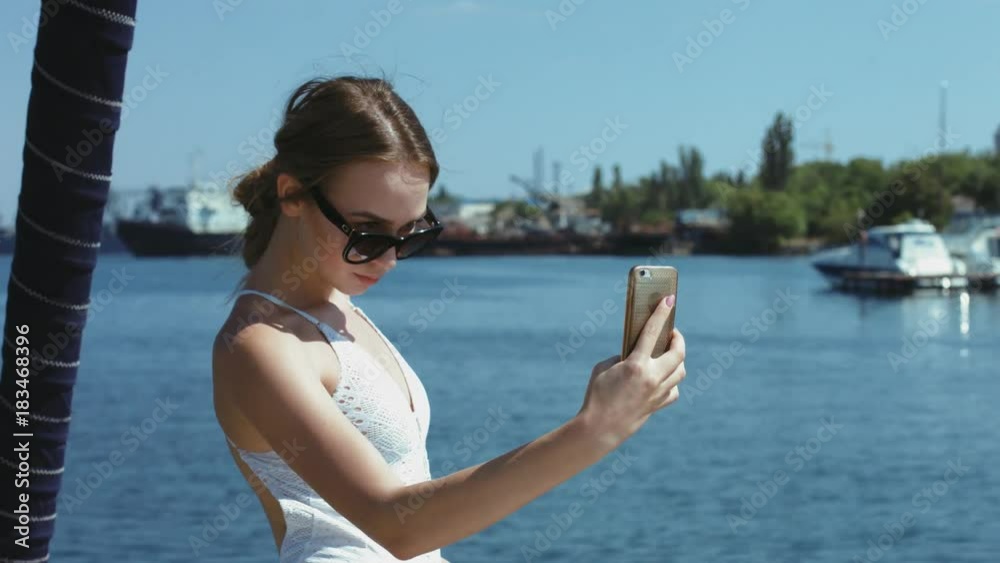 Beautiful girl in white swimsuit making selfie at yacht Beautiful girl in white swimsuit making selfie at yacht