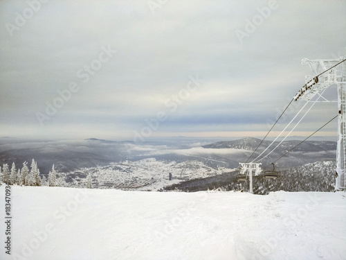 Panorama of ski resort, slope. Cold weather, the supports of the cable car in the ice. © Nick Vakhrushev
