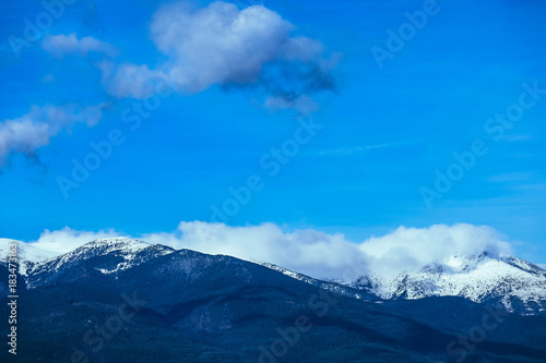 Mountain snow peak, beautiful natural winter backdrop. Ice top of the hill, blue sky background. Alpine landscape. © alicefoxartbox