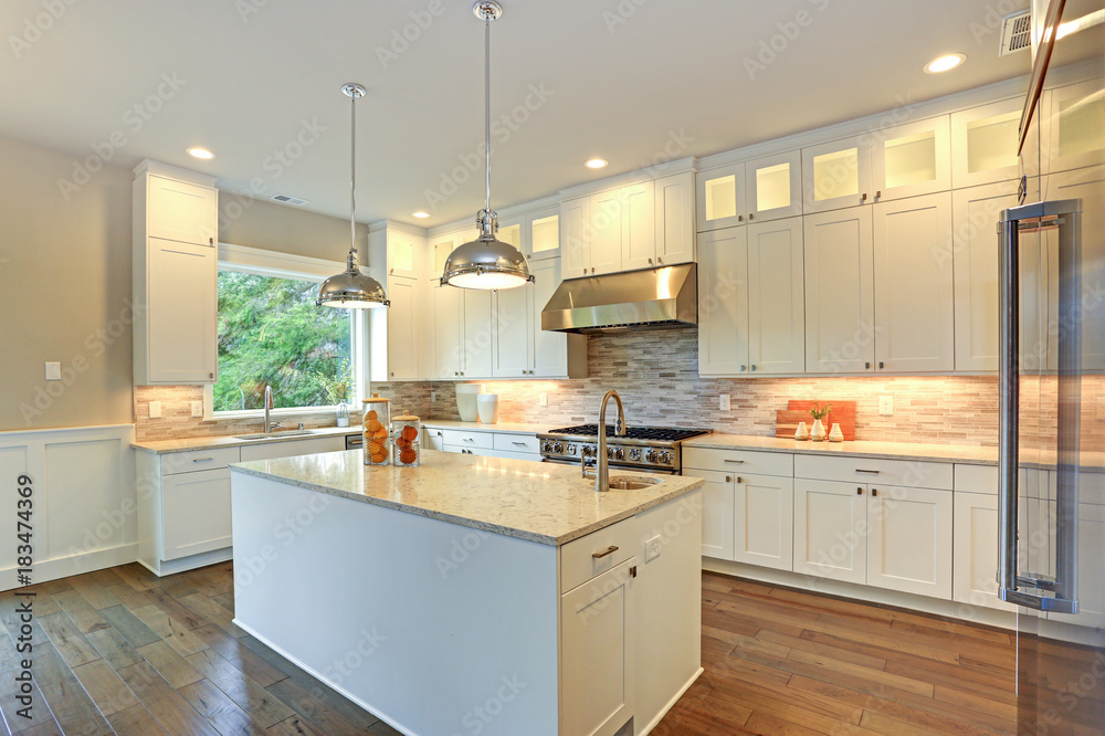 Luxury white kitchen with large kitchen island.