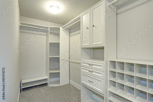 Narrow walk-in closet lined with built-in drawers