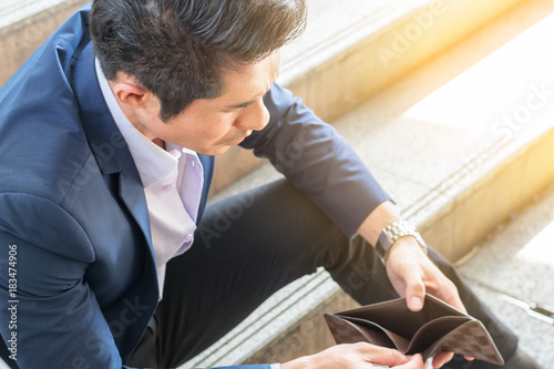 business financial concept : sad poor problem businessman holding no money open wallet