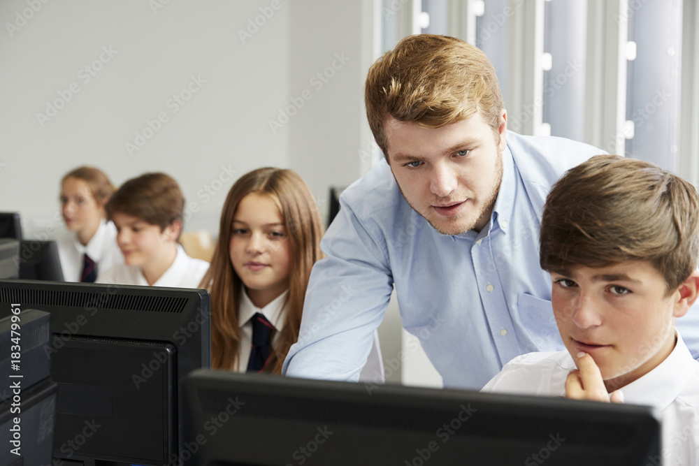 Teenage Students Wearing Uniform Studying In IT Class Teenage Students Wearing Uniform Studying In IT Class
