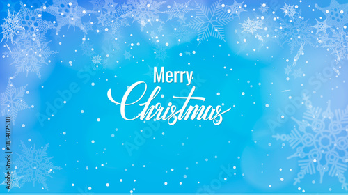 Christmas greeting on snow background. Merry Christmas words on blue winter background with snowfall.