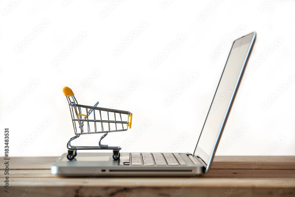 Small Shopping Cart On Laptop With Copyspace : Online Shopping Concept. E-commerce.